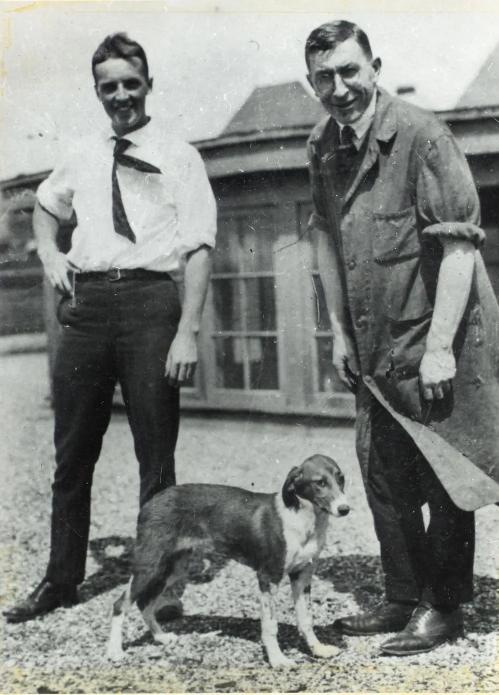 Frederick Banting and Charles Best standing beside a dog on the roof of the Medical Building at the University of Toronto, 1921